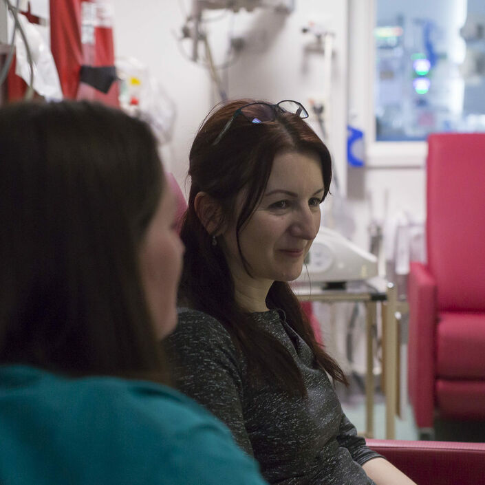 Parent looking away from the camera being supported by a friend looking towards them