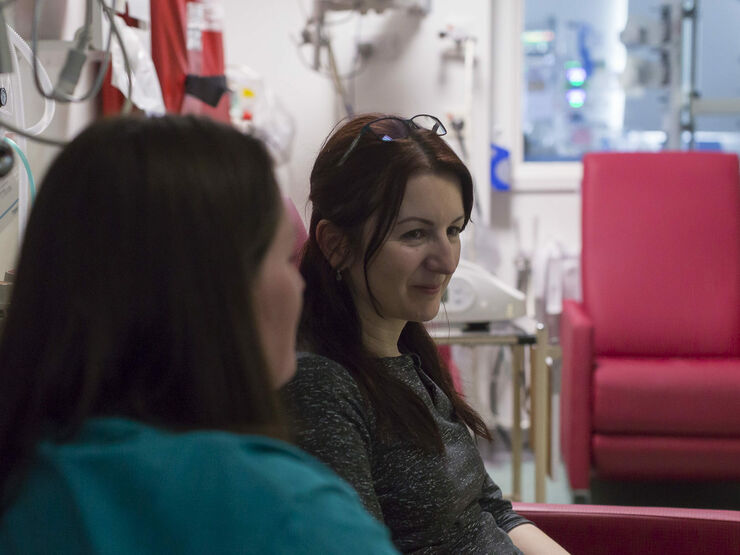 Parent looking away from the camera being supported by a friend looking towards them