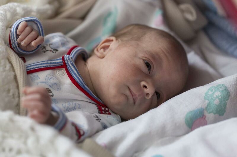 Baby lying comfortably on its bed while awake
