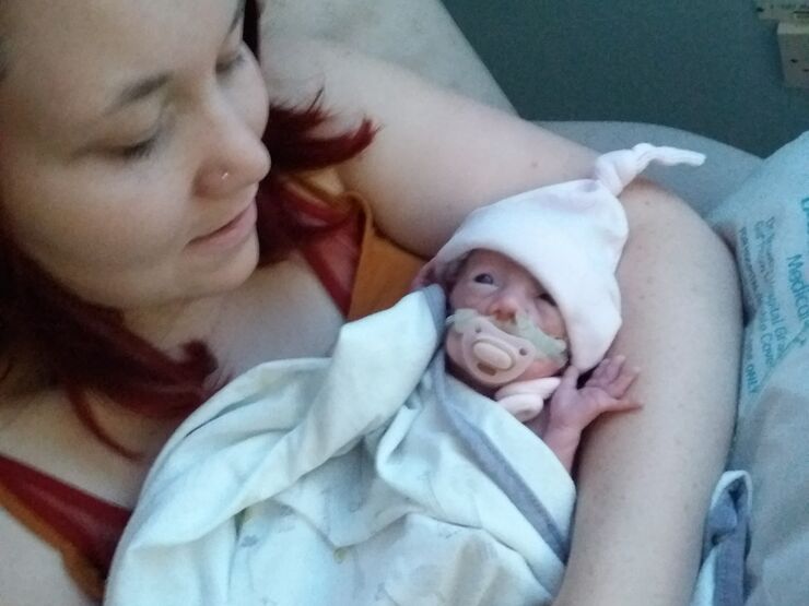 Mother holding her premature baby in a neonatal unit