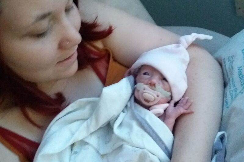 Mother holding her premature baby in a neonatal unit