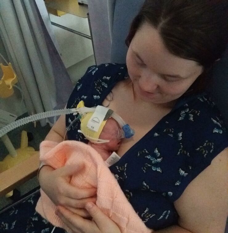 mum holding her premature baby in her arms in hospital