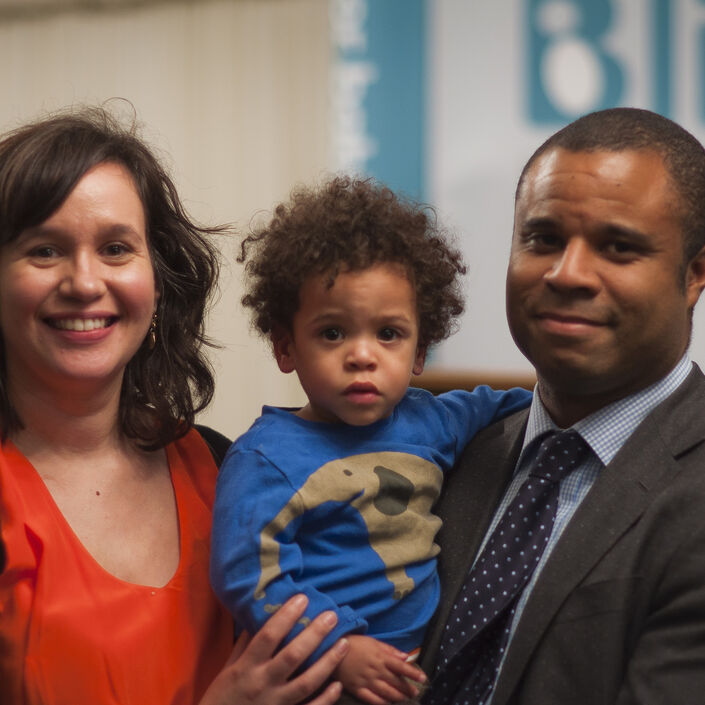 Family shot of Mum and Dad dressed smartly holding their son between them