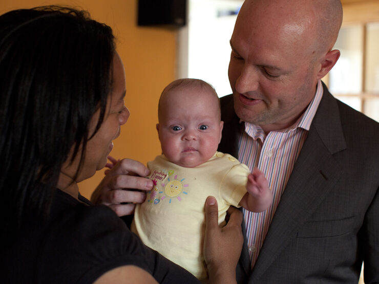 Mother and father holding their baby together