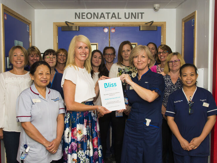 Staff at Frimley Park hospital posing while holding a Bliss accreditation plaque