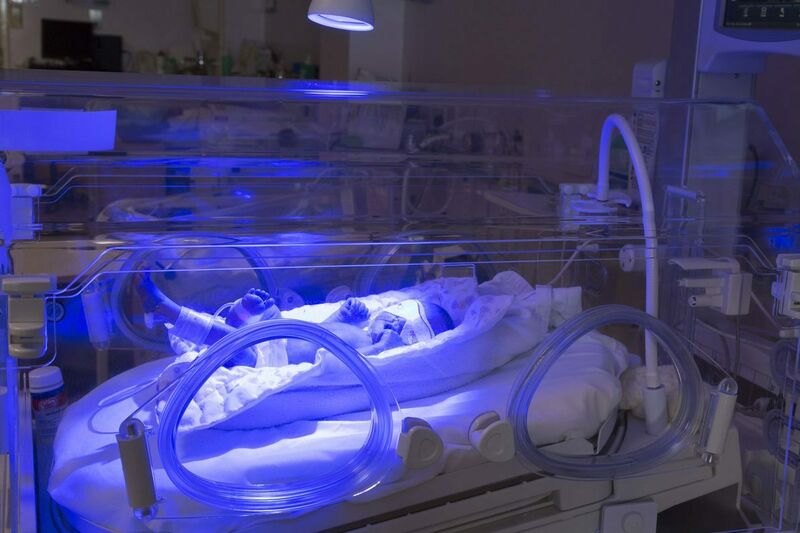 Baby in an incubator undergoing blue light phototherapy