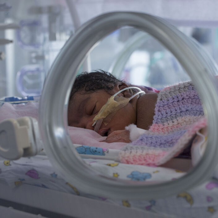 Baby with tubes in nose in an incubator