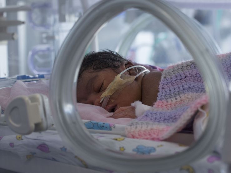 Baby with tubes in nose in an incubator