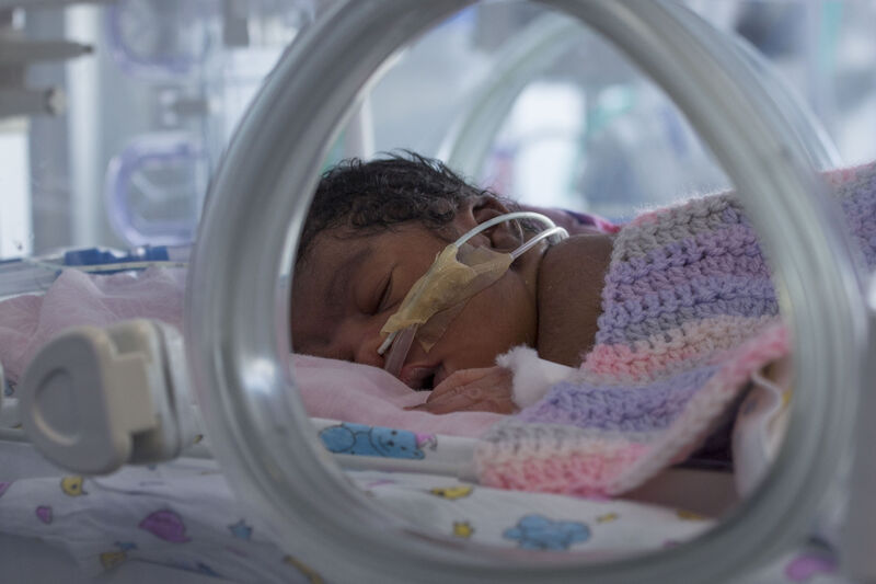 Baby with tubes in nose in an incubator