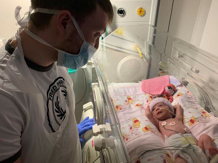 Tom looking at his baby in her incubator