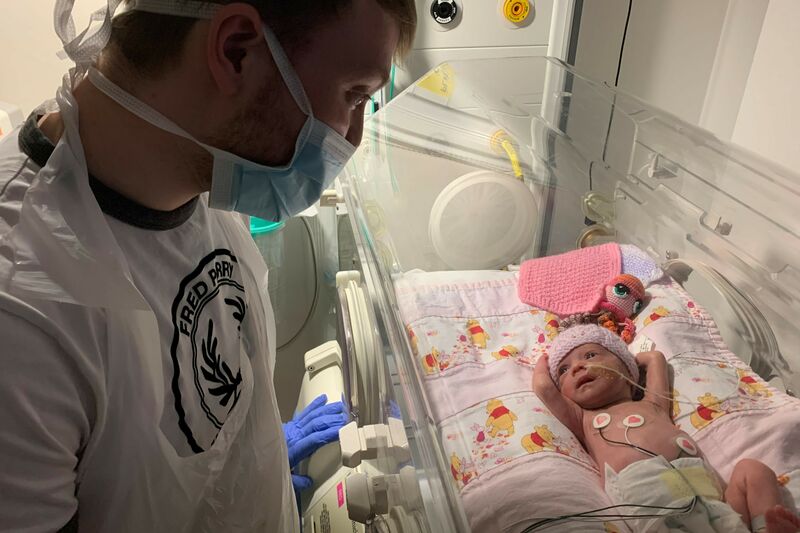 Tom looking at his baby in her incubator