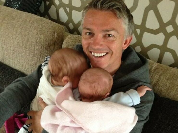 Jason holding his twins at home