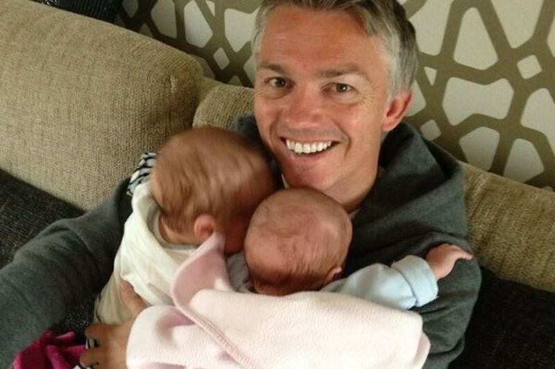 Jason holding his twins at home