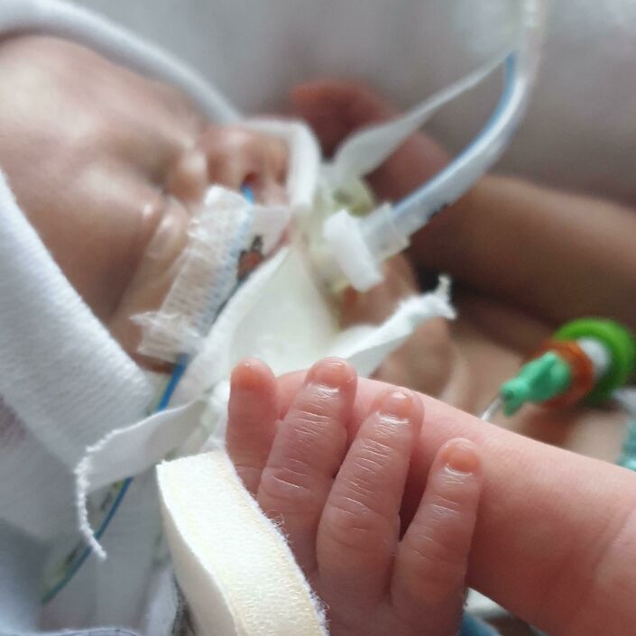 Ethan's baby holding his finger