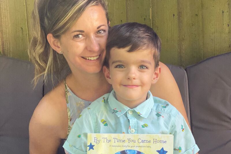 Sara and her son Ben, who is holding the children's book Sara wrote