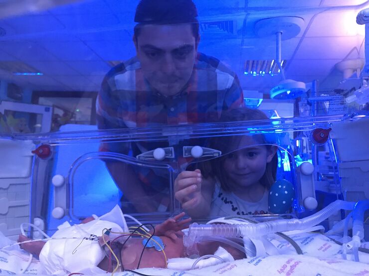 Sara's daughter and partner looking at their Ben in the incubator on the unit
