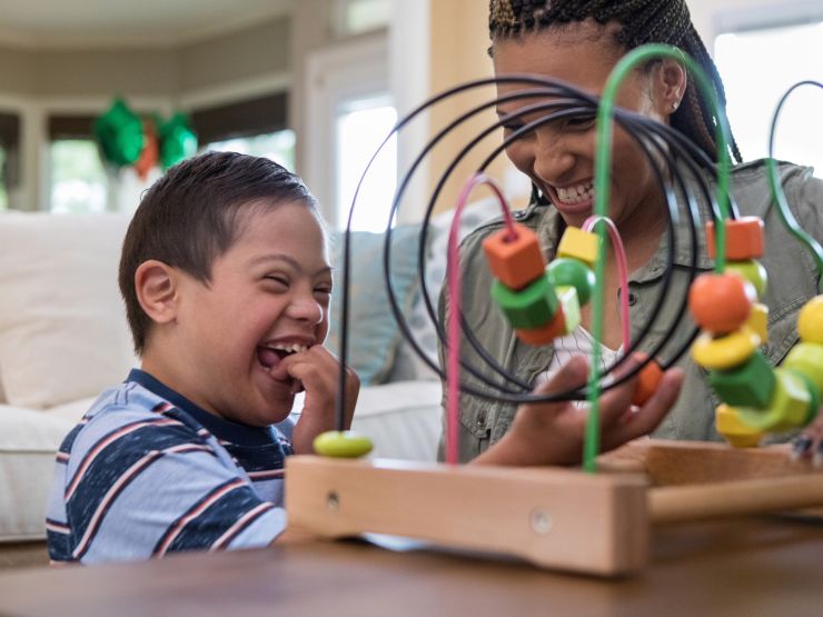 Mum and child happily playing with a toy, smiling and laughing