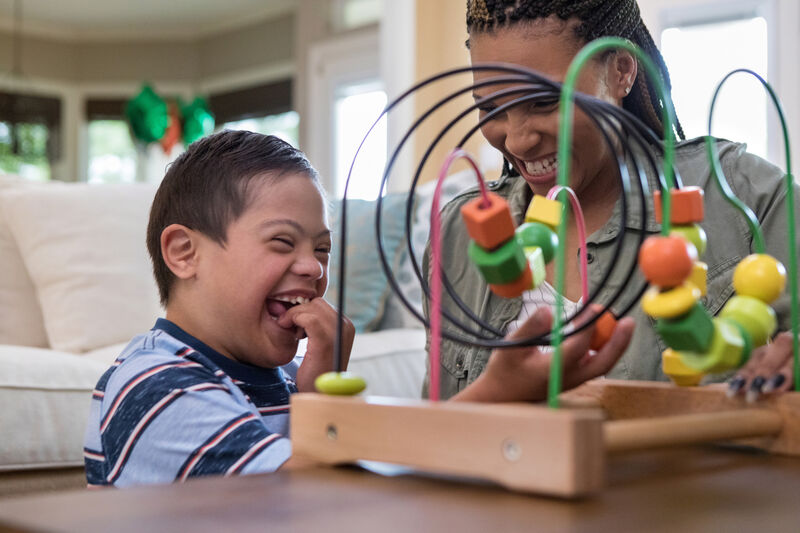 Mum and child happily playing with a toy, smiling and laughing