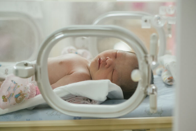Baby sleeping in incubator 1319283847