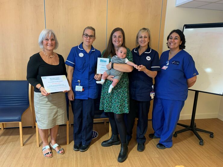 Some of the unit staff and a parent with her baby