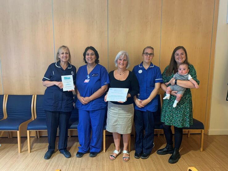 Some of the unit staff and a parent with her baby