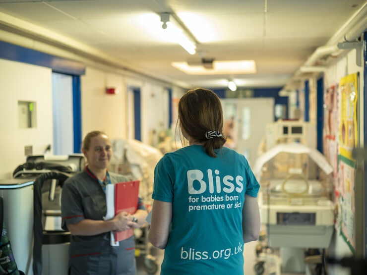 Volunteer wearing a Bliss t-shirt speaking with a nurse in a hospital setting