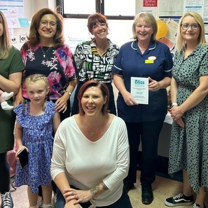 Group photo of members of hospital and Bliss staff. One person in a blue nursing uniform is holding a Bliss Baby Charter plaque.