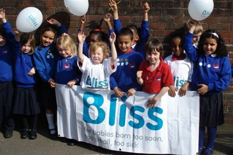 Primary school aged children with balloons and Bliss banner