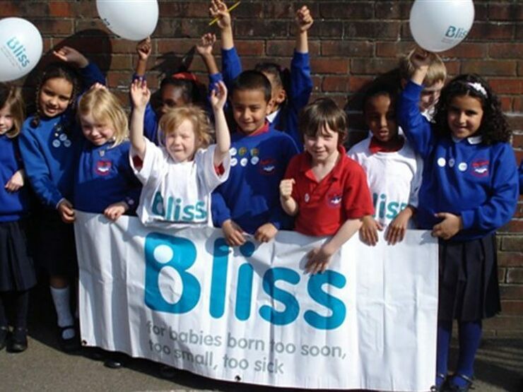 Primary school aged children with balloons and Bliss banner