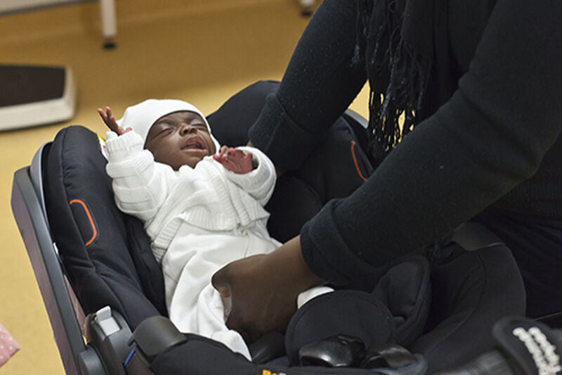 Baby being placed in car seat