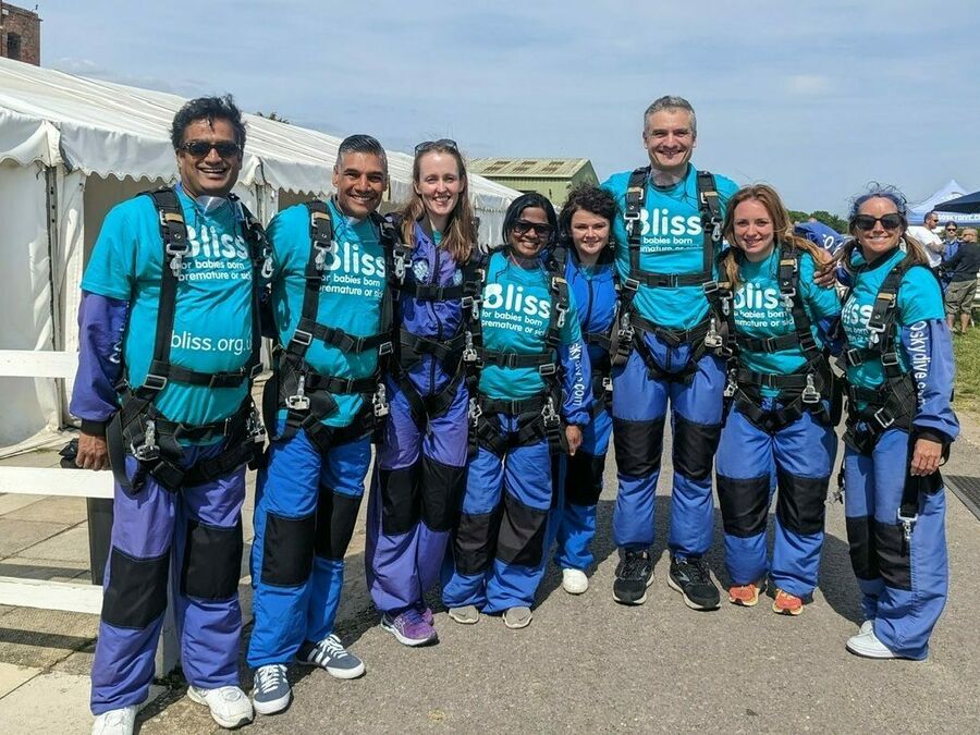 Group of people wearing skydiving suits and Bliss t-shirts