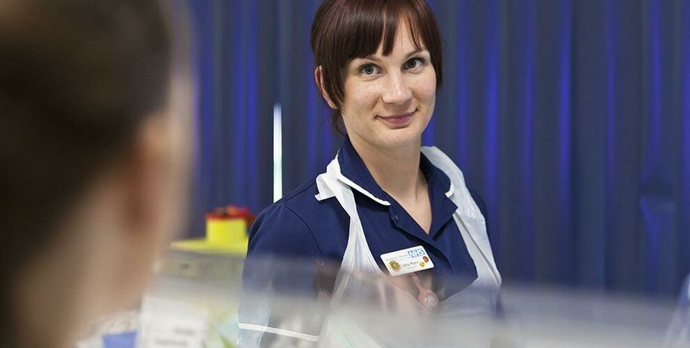 Nurse smiling in a neonatal hospital setting
