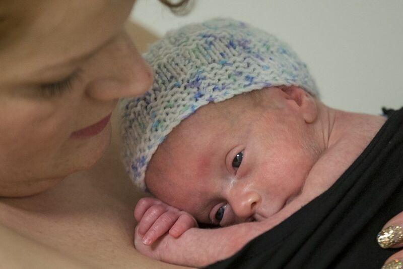 Mum cuddling baby into her skin to skin