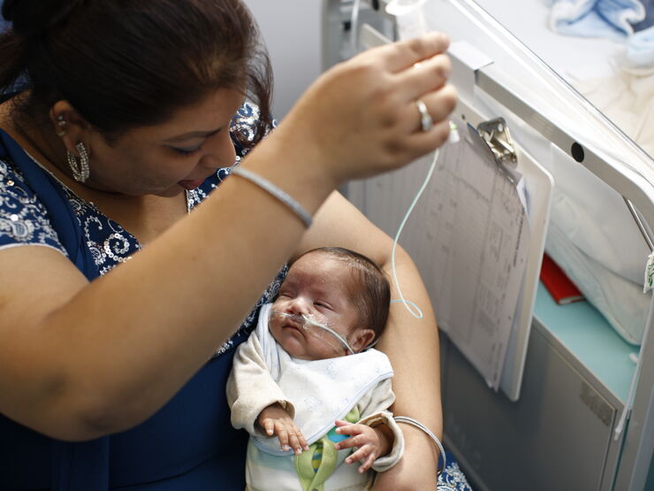Mother tube-feeding her baby in hospital