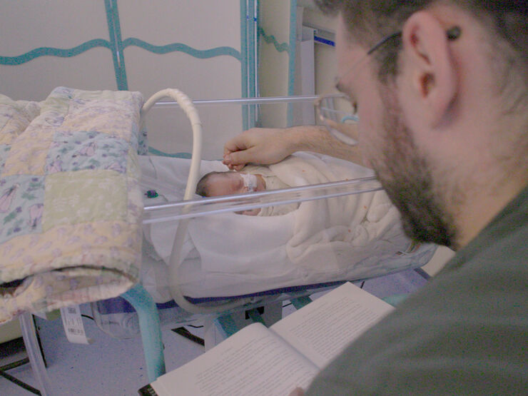 Parent caressing their sleeping baby