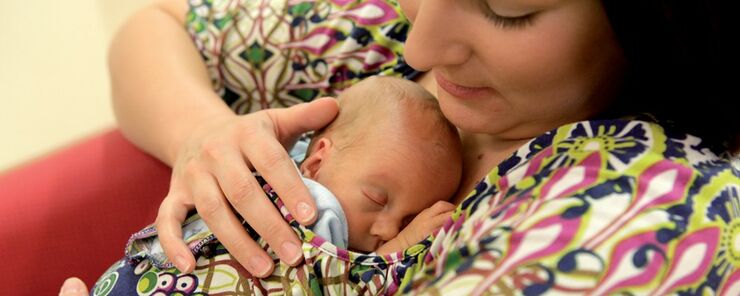 Mother holding her sleeping baby on her chest