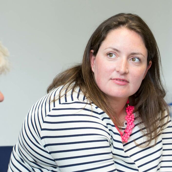 Woman sat in a group listening to speaker attentively