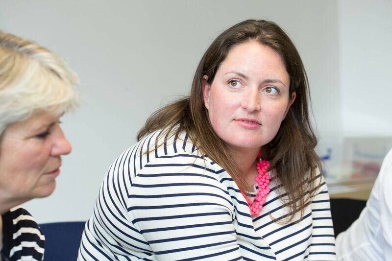 Woman sat in a group listening to speaker attentively