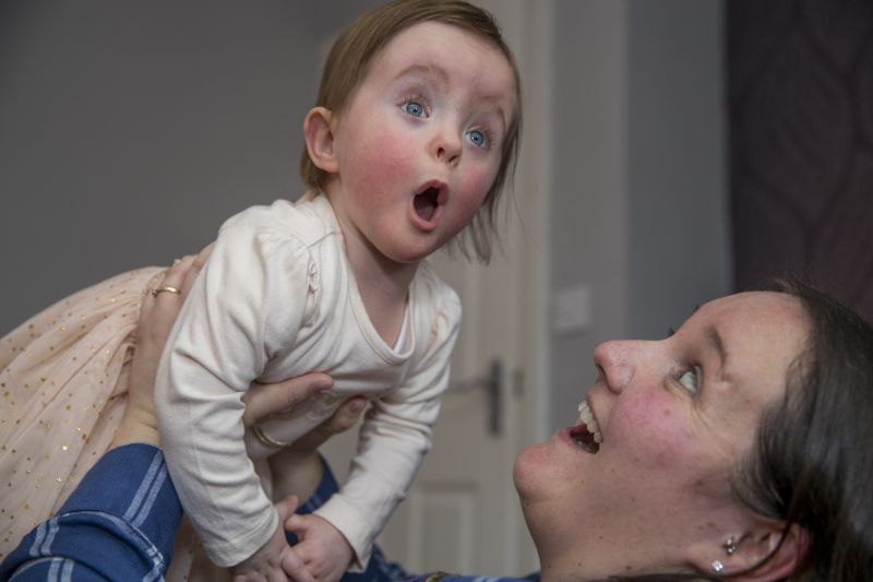 Mother lifting up her baby daughter playfully