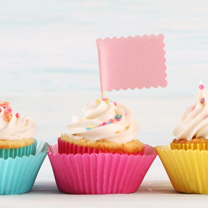 3 cupcakes lined in a row, the middle one has a flag in it