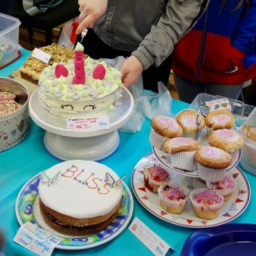 Table of baked cakes, one iced as a unicorn