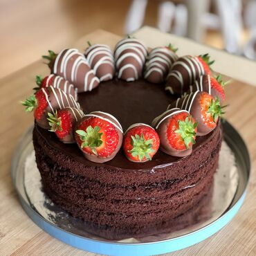 A four tier chocolate cake with strawberries on top