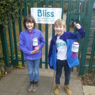 two young pupils at non school uniform day with Bliss t-shirts and collection tins