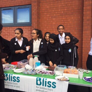 Pupils holding a cake sale at School with Bliss branding