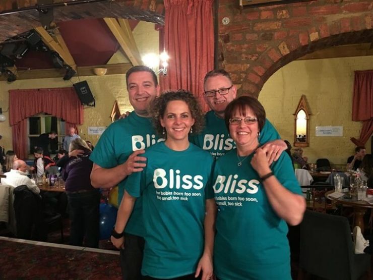 Group of 4 wearing Bliss t-shirts in a venue where they have organised an event