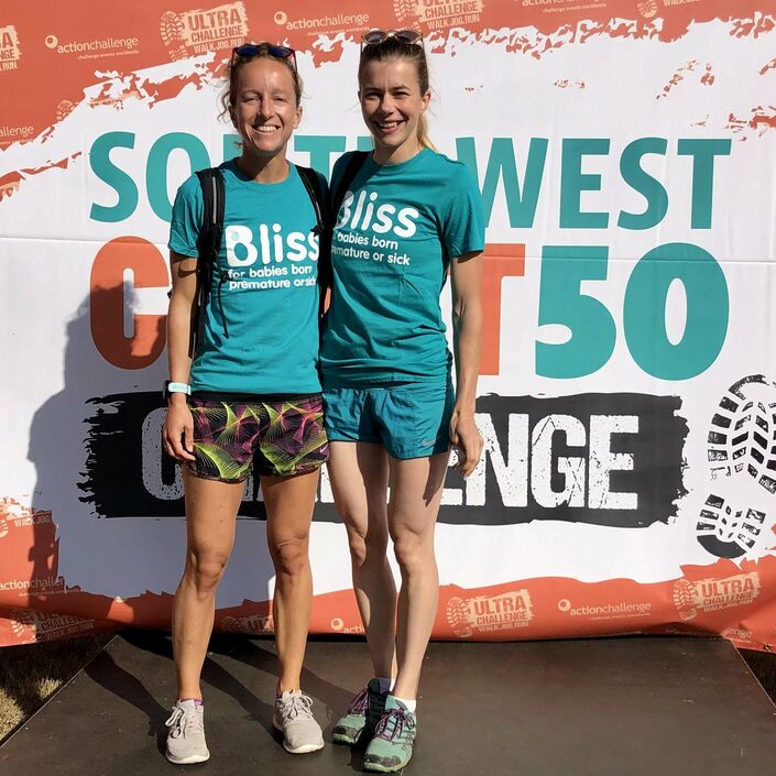 2 bliss walkers in bliss t-shirts on the event podium smiling