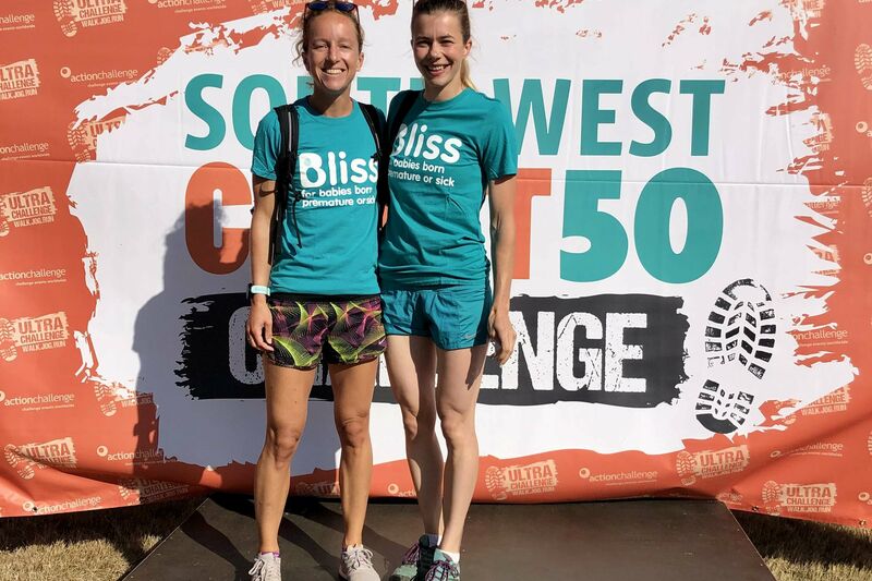 2 bliss walkers in bliss t-shirts on the event podium smiling