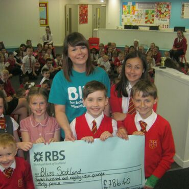 Bliss representative collecting cheque from school children