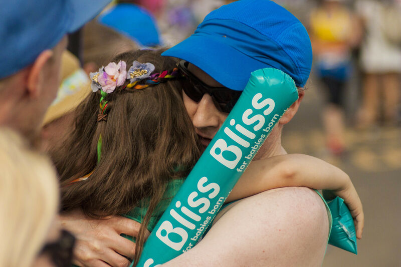 Man taking part in running event hugging a Bliss supporter