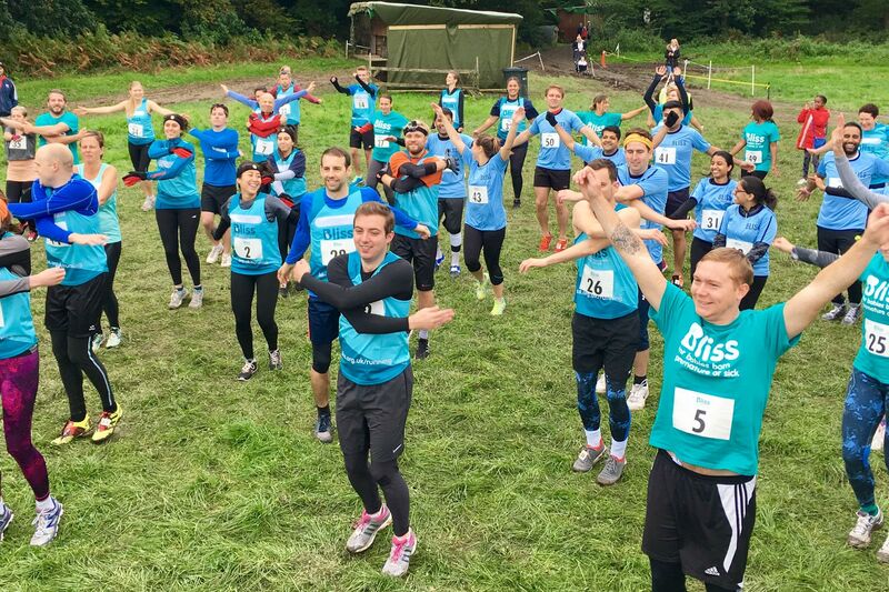 People wearing Bliss t-shirts and vests warming up to take part in a mud run